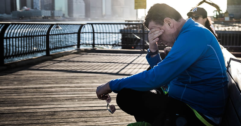 Weary man with head in hand